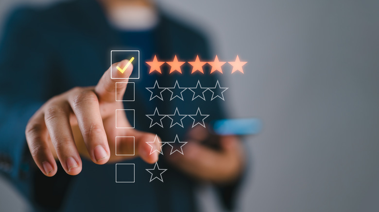 A finger pointing at a five-star holographic rating graphic.