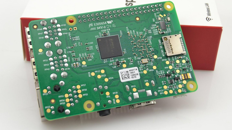 A Raspberry Pi circuit board and its packaging, representing a DIY car infotainment core.