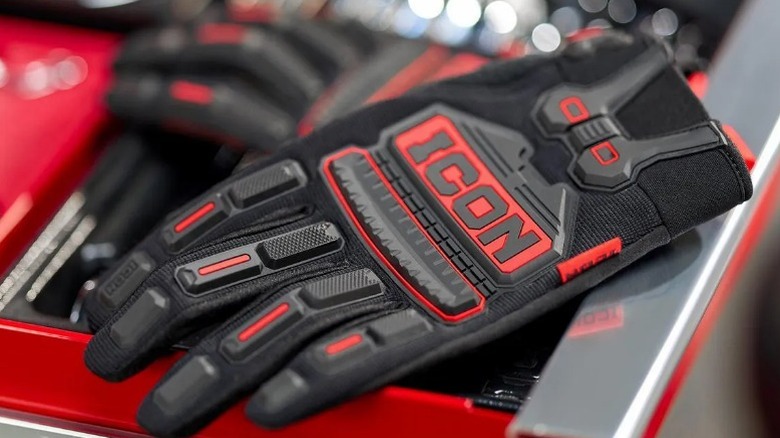A pair of Icon Master Technician Premium Gloves resting on the edge of a professional tool chest.
