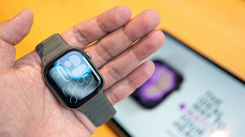 A person holding the Apple Watch Series 11 in their palm to show its scale and design.