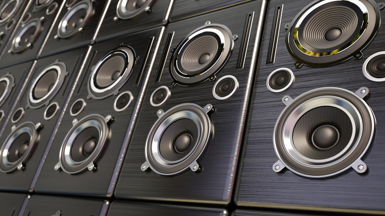 A collage or mosaic featuring various small bookshelf and satellite audio speakers.