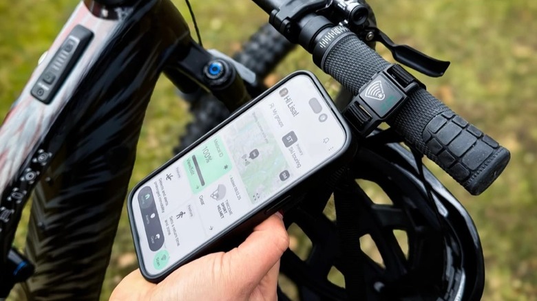 A smartphone being held close to a FIDLOCK SNAP buckle to scan the integrated Twiceme NFC medical ID.