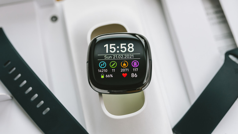 A close-up of a wearable fitness tracker screen showing biometric data.