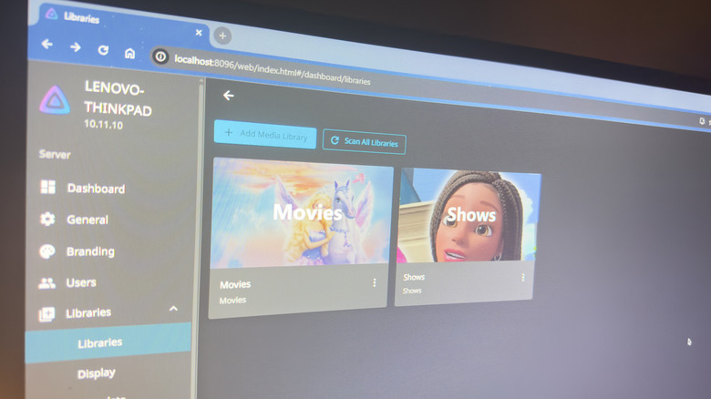 A computer monitor displaying the Jellyfin dashboard with rows of high-resolution movie posters.