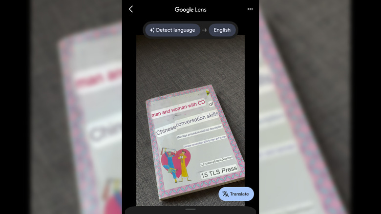 Google Lens translating a Chinese phrasebook cover into English in real-time.
