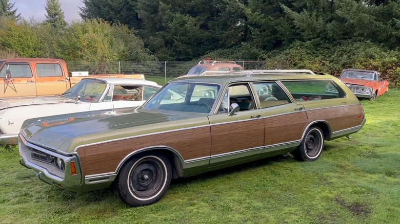 A pea-green Dodge Royal Monaco station wagon with wood-grain paneling parked on grass.
