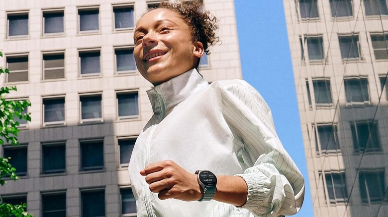 A woman running outdoors while wearing a Samsung Galaxy Watch 7 to track her workout.