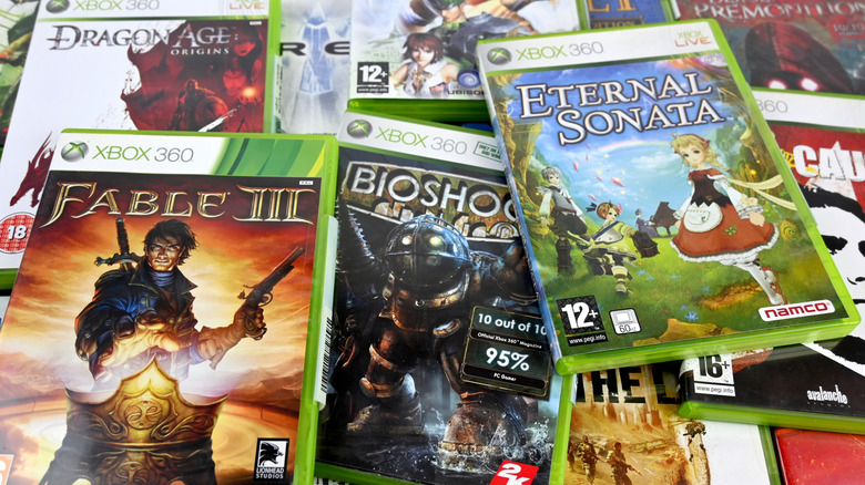 A large stack of green Xbox 360 game cases and discs.