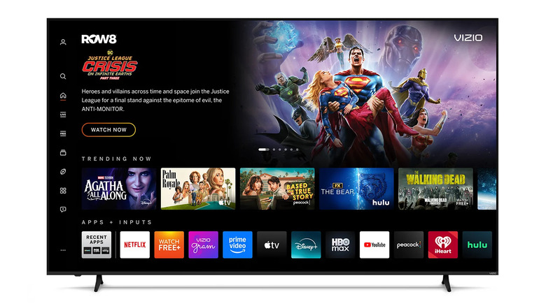A massive Vizio 100-inch QLED TV showing various streaming apps on its home screen.