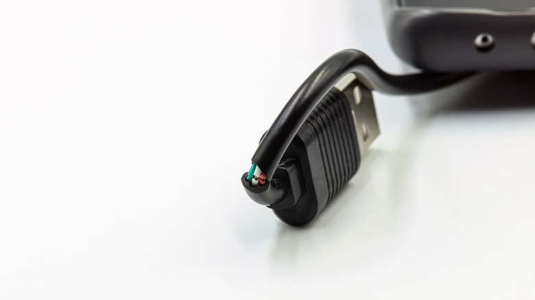 Close-up of a USB cable with a frayed and damaged outer casing near the connector.