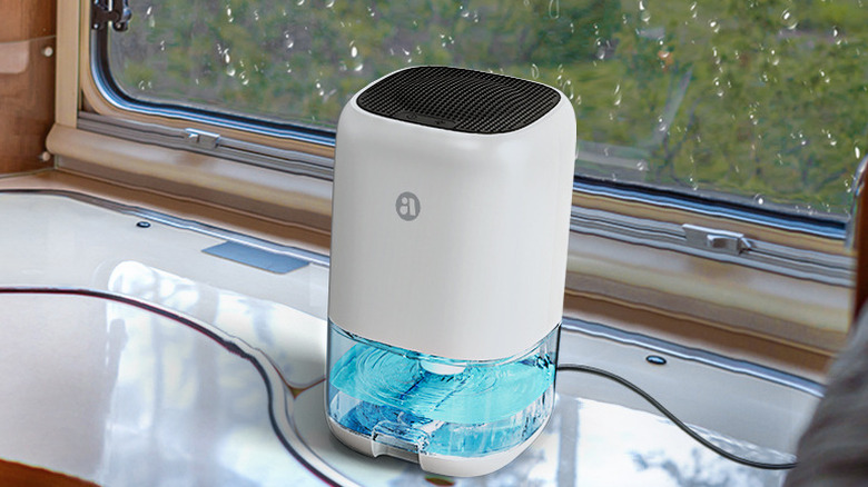 A Tabyik portable dehumidifier sitting on a surface inside an RV near a window.