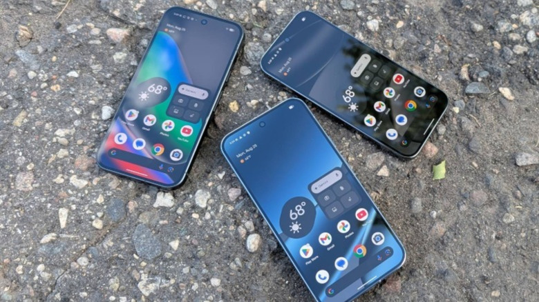 Multiple Google Pixel phones laid out on a pavement background.