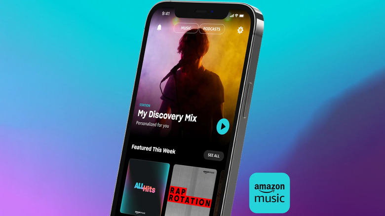 A hand holding a mobile phone with the Amazon Music app open on the home screen.