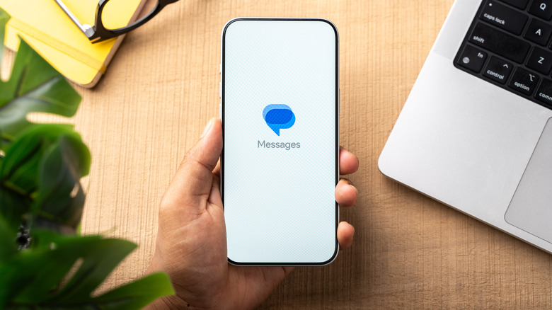Top-down view of a smartphone with the Google Messages icon visible on the display.