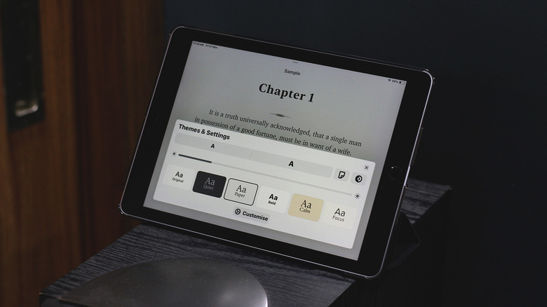Close-up of an iPad running the Apple Books app with text customization menu open.