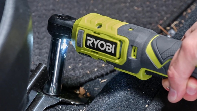 A user utilizing the slim-profile Ryobi 4V cordless ratchet for mechanical work.