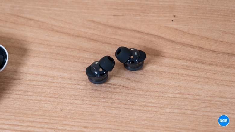 A pair of Google Pixel Buds 2a earbuds lying on a flat surface showing the silicone stabilizers.