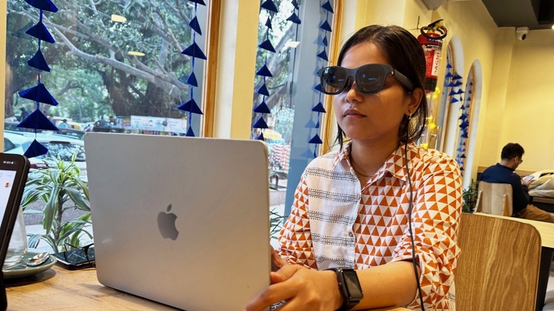A person wearing AR smart glasses in a seated position, looking forward comfortably.