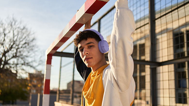 A person wearing black JBL Tune 520BT headphones while outdoors, showing the on-ear fit.