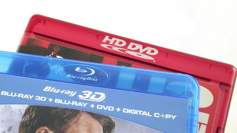A red HD-DVD case positioned underneath a blue Blu-ray case.