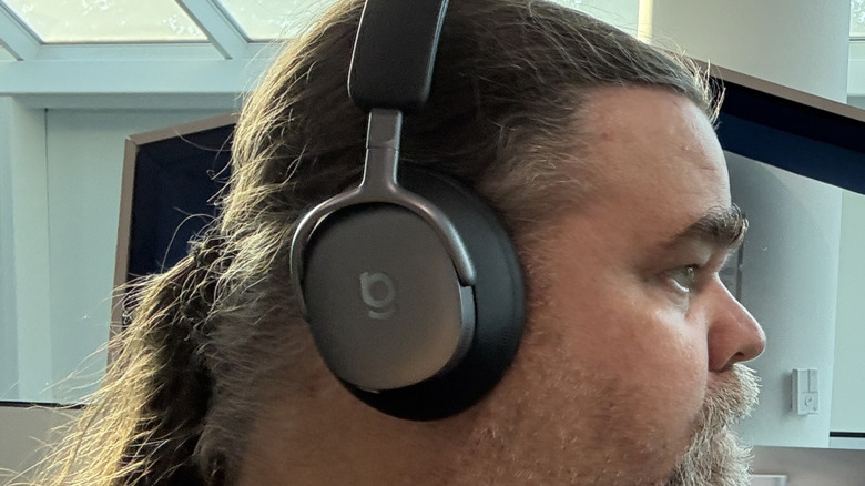 Front-side view of a man wearing the Baseus Inspire XH1 over-ear headphones.