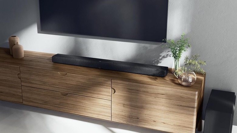 The Yamaha True X Bar 50A soundbar and its companion subwoofer on a compact light brown TV unit.