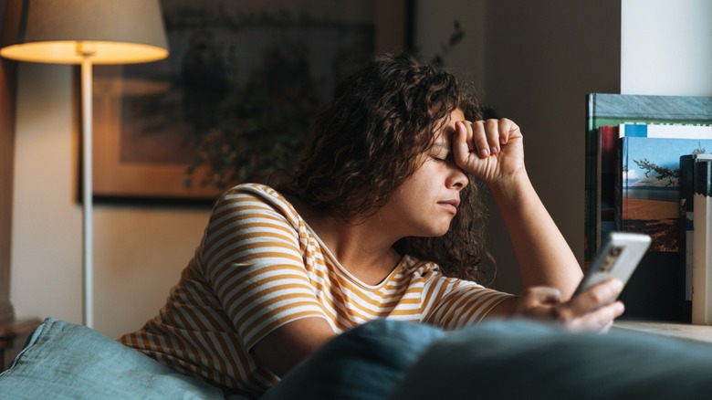 A woman looking frustrated while using her Android smartphone.