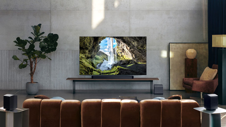 The Samsung HW-Q990F soundbar with its dedicated subwoofer and rear satellite speakers in a home setting.