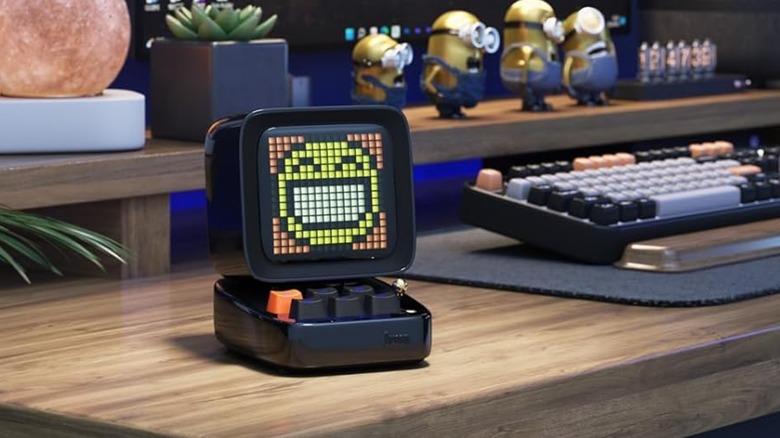 A Divoom Ditoo speaker on a desk displaying colorful pixel art.
