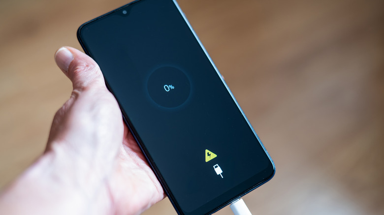 Close-up of a smartphone screen showing a battery level of zero percent.