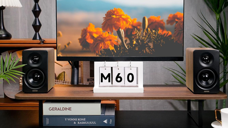 A pair of Edifier speakers on a TV stand flanking a large television