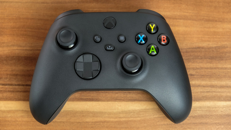 Close-up of a black Xbox Series X wireless controller connected via a USB cable.