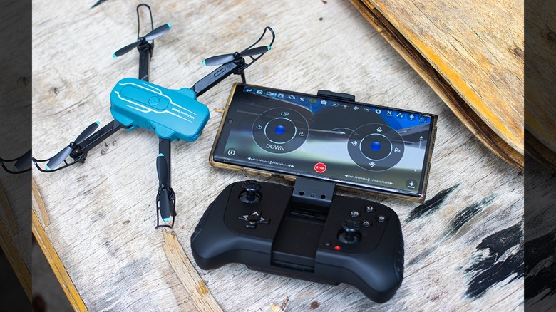 The Oviliee S17 remote controller with a smartphone mounted on top running the FPV app.