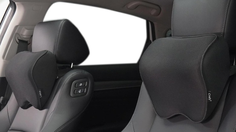 Two Crofy ergonomic memory foam neck pillows installed on the headrests of leather car seats.