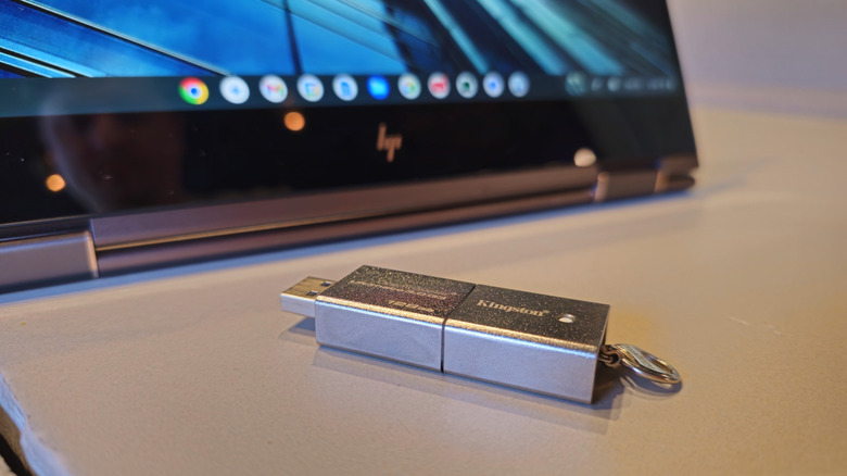 A high-performance flash drive sitting next to a Chromebook laptop.
