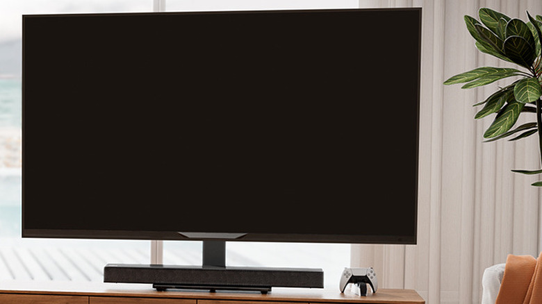 A television mounted on a sleek, adjustable universal swivel stand on a cabinet.