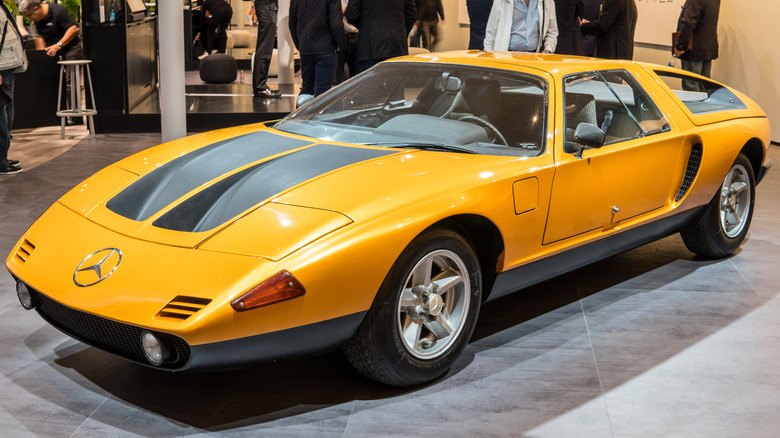 The orange Mercedes-Benz C-111 experimental vehicle with its distinctive wedge shape and gullwing doors.
