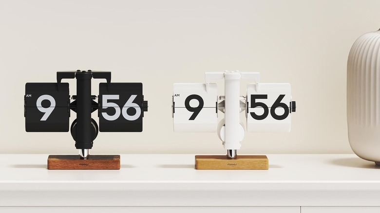 A vintage style Mooas flip desk clock with black cards and white numbers against a minimalist background.