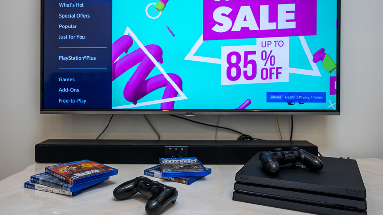 A PlayStation 4 Pro console and DualShock 4 controllers on a table.