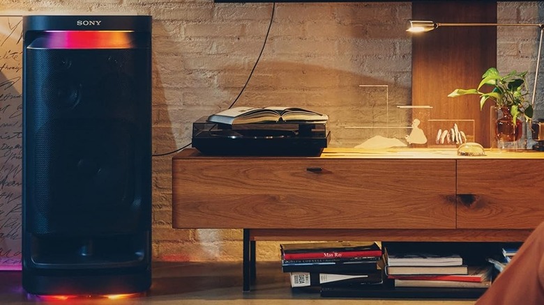 Sony SRS-XV900 speaker connected to a wall-mounted TV using an optical cable.