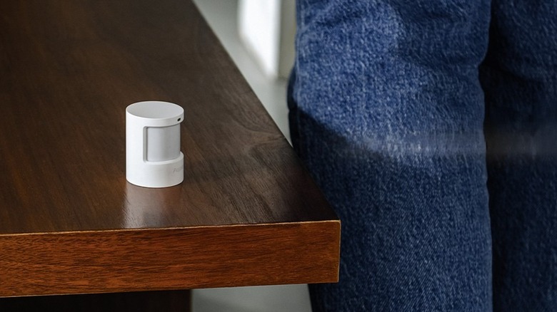 An Aqara Motion and Light Sensor P2 placed on a table surface.