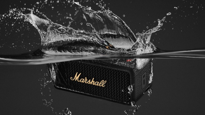 A Marshall Emberton III speaker being submerged in water.