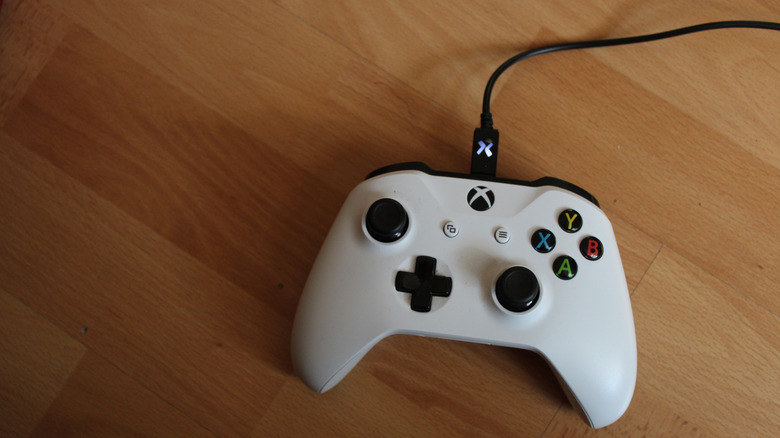 An Xbox One controller connected to a device via a sturdy USB data cable.