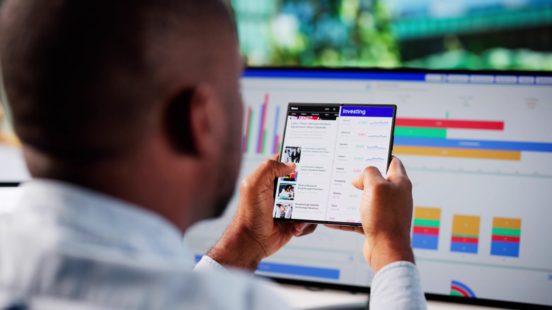 A person interacting with two different apps simultaneously on a large foldable Android screen.