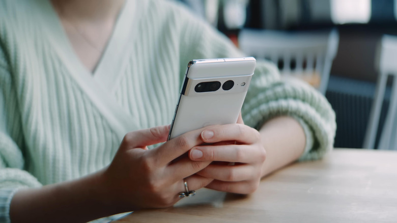 A user interacting with a Google Pixel phone in a casual setting.