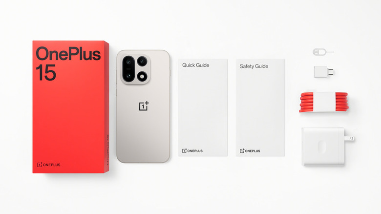 The OnePlus 15 on a white table with its fast-charging cable and accessories.