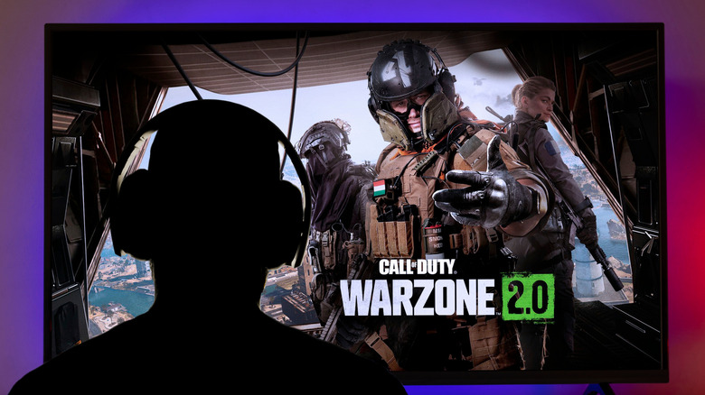 A person playing Call of Duty Warzone on a large screen using an Xbox console.