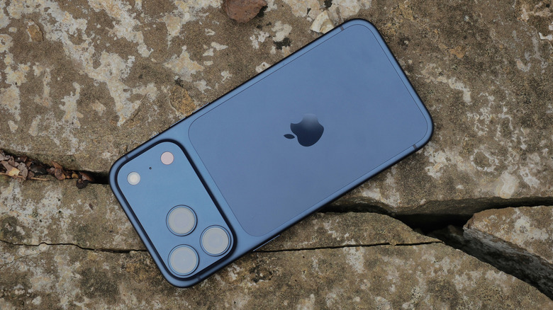 Close up of the iPhone 17 Pro rear panel resting on natural grey rocks.