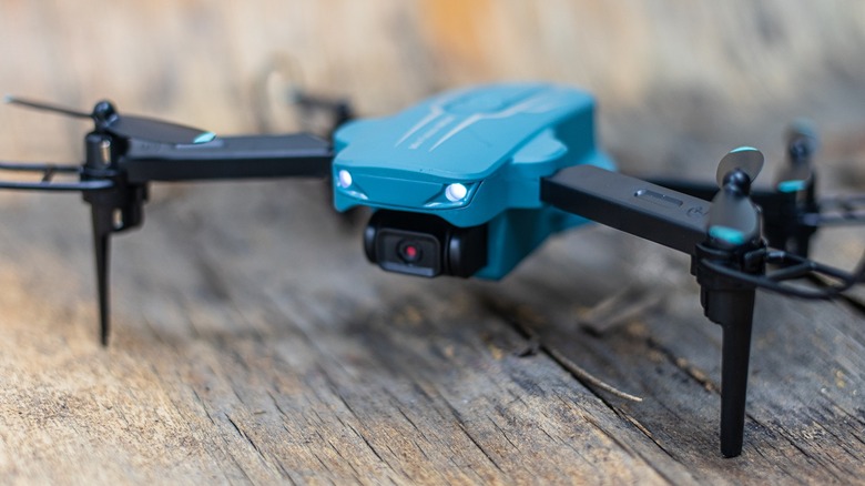 Close-up of the Oviliee S17 mini drone with its front lights illuminated.