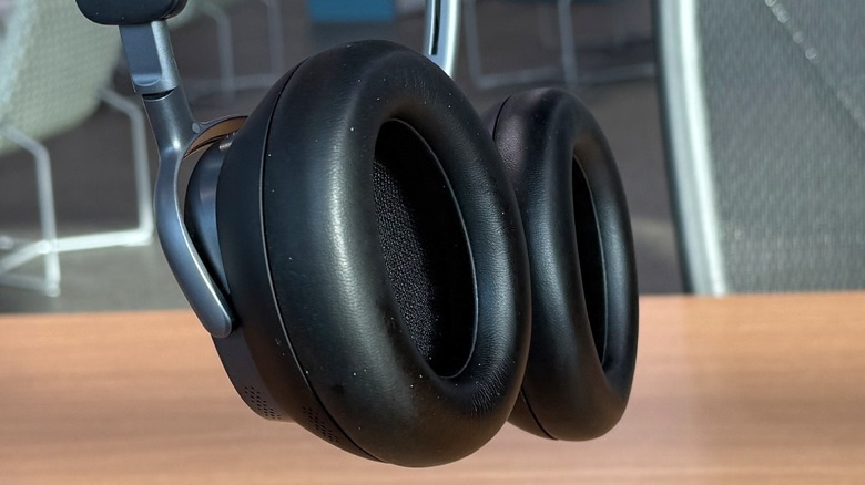 Close-up of a person's hand holding the ear cup of the Baseus Inspire XH1.